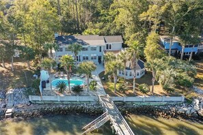 A large house with a swimming pool, surrounded by palm trees and a dock. - Dreamworthy, waterfront St. Helena home with pool and deep water dock. (St. Helena)