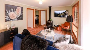 Un salon avec un canapé, une table basse, une cheminée et un tableau au mur.