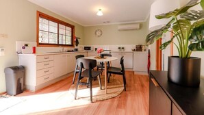 Une cuisine compacte avec un coin repas, comprenant une table ronde, des chaises et une plante en pot.