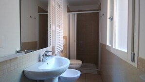 A bathroom with a sink, toilet, and shower. - GetTheKey Boldrini Loft 2 (Bologna)