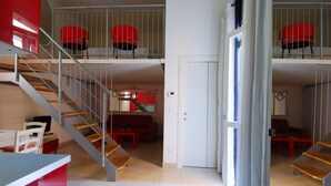A spacious apartment with a staircase leading to a balcony, a dining area, and a living room. - GetTheKey Boldrini Loft 2 (Bologna)