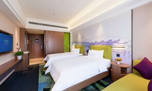 Habitación de hotel con dos camas, un televisor, un escritorio y un mural con vistas a la ciudad.