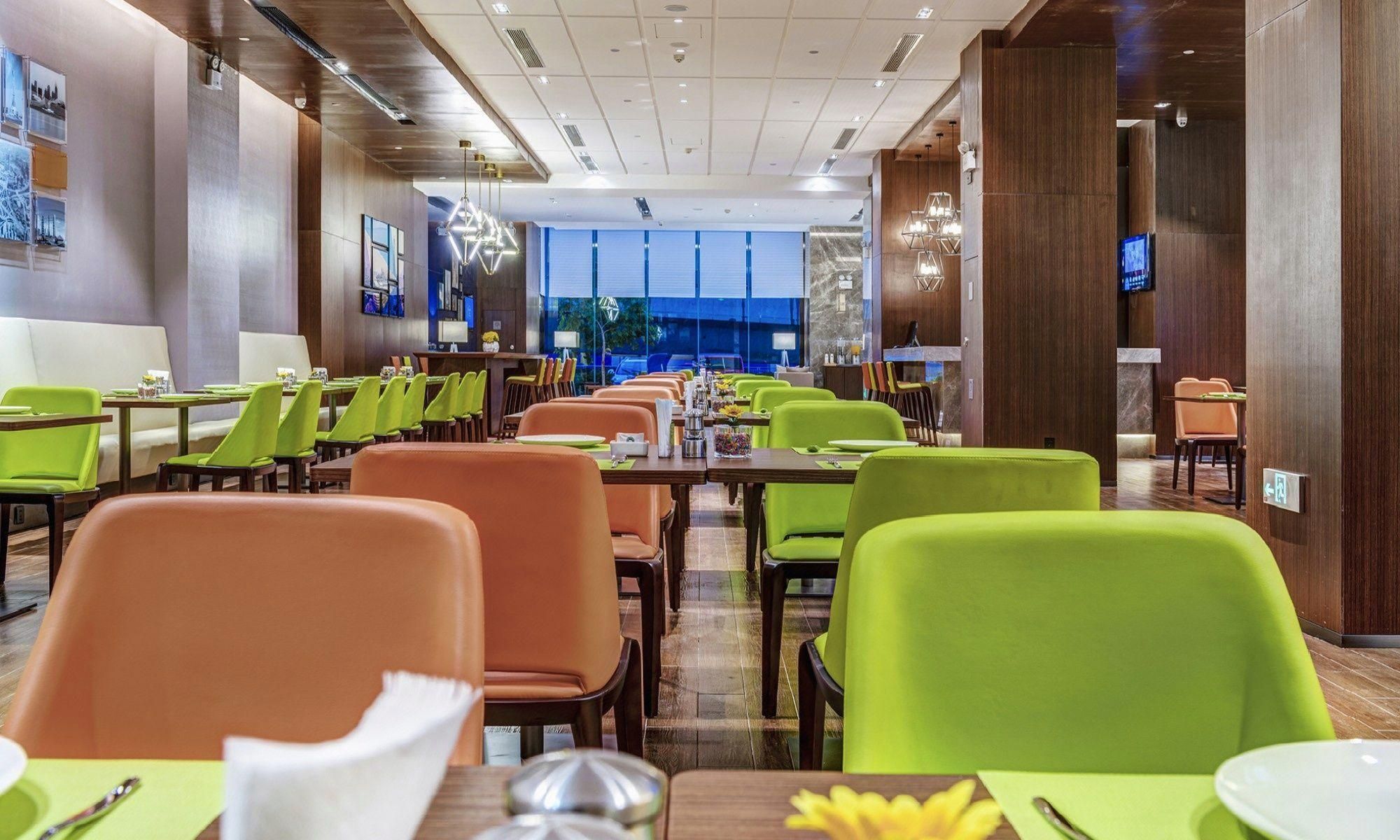 A restaurant with multiple tables and chairs, a modern interior design, and a view through the windows.