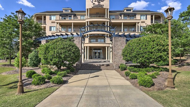 A hotel with a prominent sign, a central entrance, and a landscaped front yard with trees and shrubs. - Cozy Auburn Studio < 1 Mile to University! (Auburn)