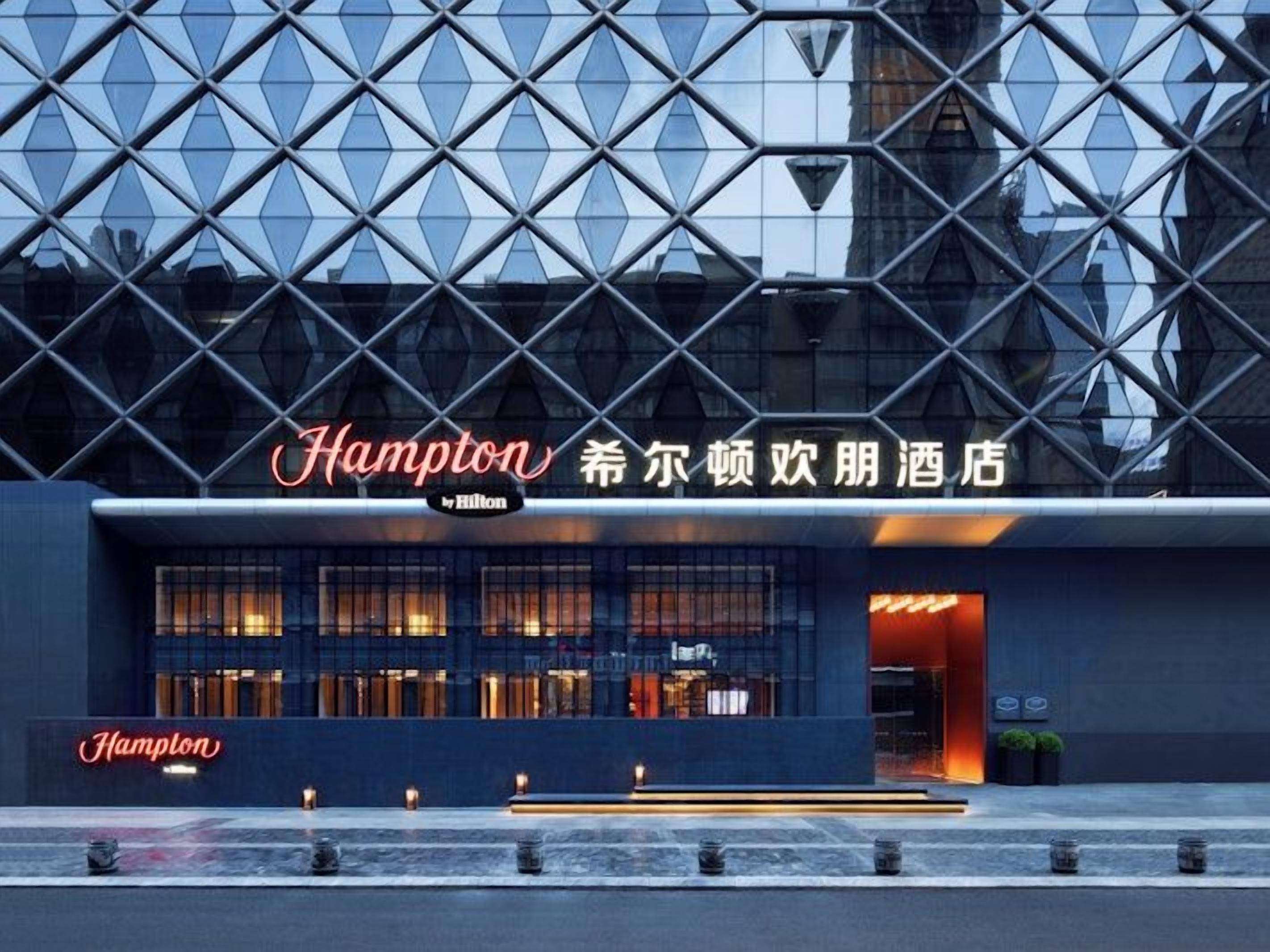 A modern hotel with a distinctive geometric facade and illuminated signage.