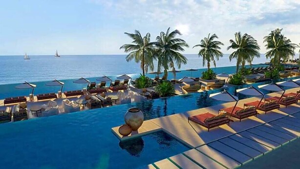 A resort pool with lounge chairs and umbrellas, palm trees, and a view of the ocean. - The Royal Senses Resort & Spa Crete, Curio Collect (Mylopotamos)