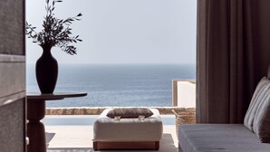 A balcony with a view of the sea, a sofa, a small table with a vase, and a curtain. - The Royal Senses Resort & Spa Crete, Curio Collect (Mylopotamos)