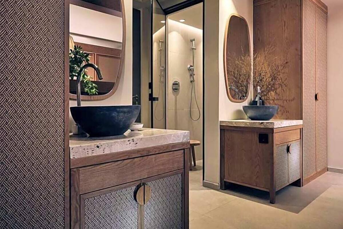 A modern bathroom with a large mirror, a bowl sink, and a walk-in shower.