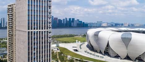 A modern building with a glass facade and a distinctive curved roof structure.