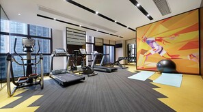 Un gimnasio moderno con cintas de correr, elípticas y pesas libres.