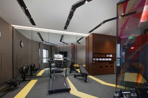 Ein modernes Fitnessstudio mit Laufbändern, Fahrrädern und Gewichten.