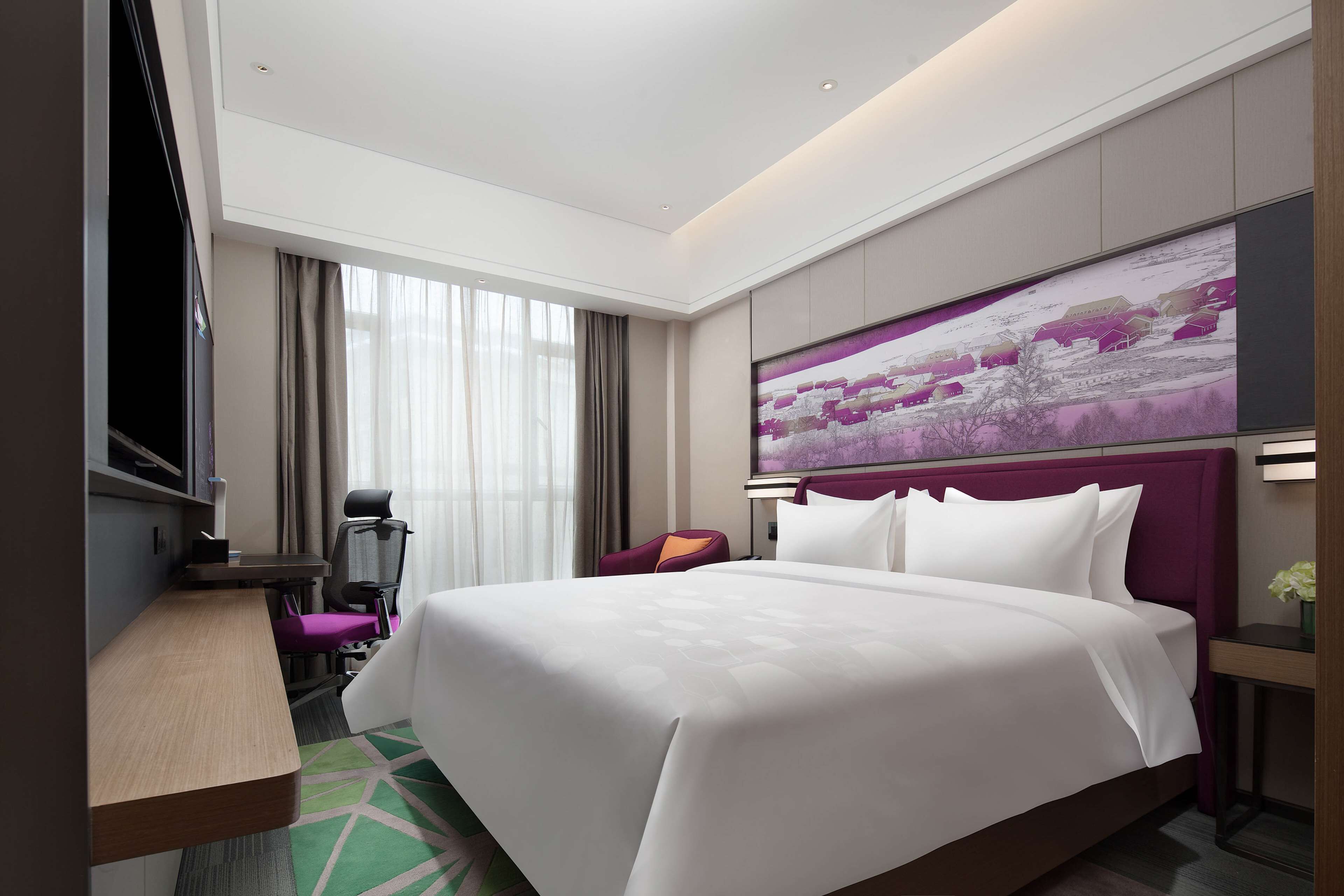 A hotel room with a large bed, a desk, a chair, a TV, and a painting on the wall.
