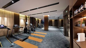 A modern gym with treadmills, elliptical machines, and exercise bikes.