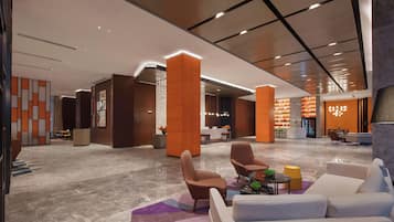 A modern lobby with seating areas, a reception desk, and a bar area.