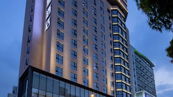 A hotel with a prominent 'Hampton' sign, large windows, and a modern architectural design.