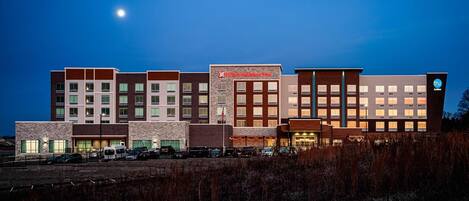 A multi-story hotel with a modern architectural design, featuring a mix of brick and stone facades, and a prominent garden center sign.