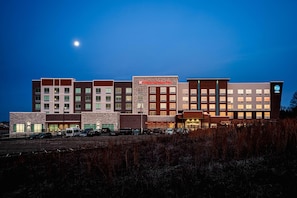 A multi-story hotel with a modern architectural design, featuring a mix of brick and stone facades, and a prominent garden center sign. - Hilton Garden Inn Mt.juliet (Mount Juliet)