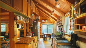 Una cucina accogliente con mobili in legno, zona pranzo e vista sull'esterno.
