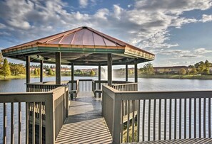 A gazebo with a metal roof and wooden deck, overlooking a body of water with a clear sky. - Beautiful lakeview townhouse near Disney (Kissimmee)
