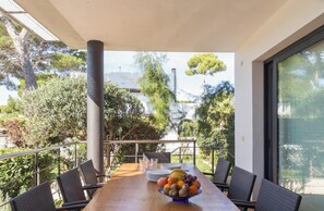 Ein Balkon mit Esstisch, Stühlen und einer Obstschale.