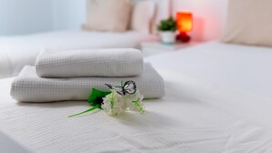 A neatly made bed with folded white linens, a small decorative butterfly, and white flowers on the bed. - Suitur apartment with pool in Marbella beach (Marbella)