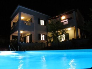 En toetagers bygning med en swimmingpool foran.