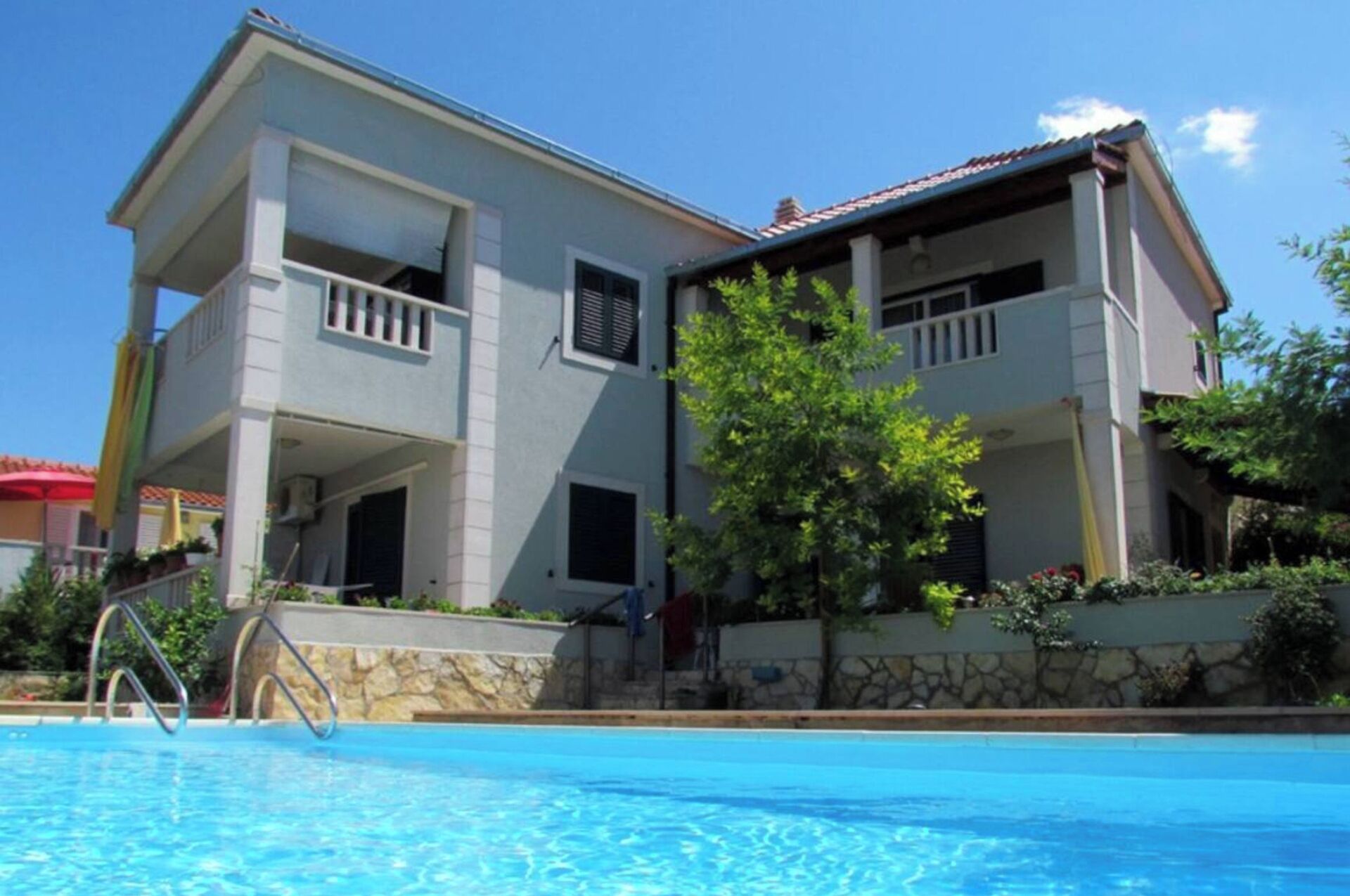 A two-story building with a swimming pool in front.