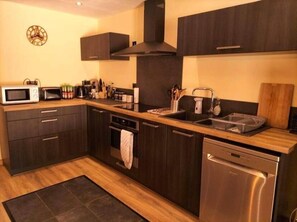 Enjoy cooking in this fully equipped kitchen with appliances, including a microwave, toaster, coffee maker, and dishwasher.