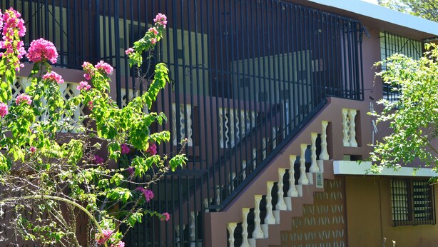 Ein Gebäude mit Treppe und Zaun.