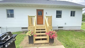 A house with a front porch, a grill, and flower planters.