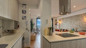 Una cocina moderna con armarios de madera clara, una isla central y vistas al exterior.