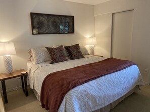 Cozy retreat with a neatly made bed, patterned bedspread, and throw blanket.