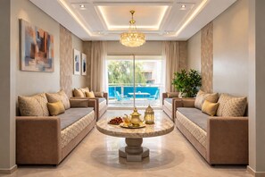 Un salon moderne avec deux canapés, une table basse ronde et un lustre.