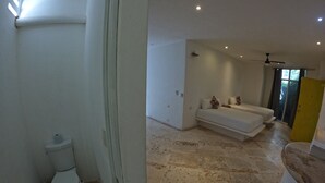 Et badeværelse med toilet, vask og bruseområde.