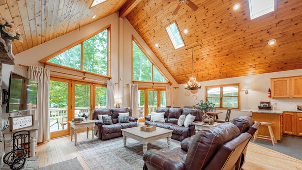 Ein geräumiges Wohnzimmer mit hoher Decke, großen Fenstern und einem gemütlichen Kamin.