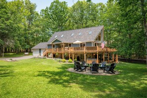 Una casa de dos pisos amb una terrassa, mobiliari d'exterior i una bandera dels Estats Units.