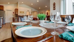 A dining area with a wooden table set for four, surrounded by chairs. - Fantastic Family Friendly Home w/ Moutain View, Huge Fenced yard, Private Backyard and Patio, A/ (Redmond)