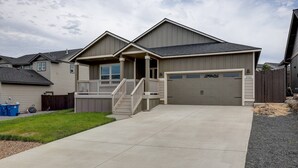 A two-story house with a front porch, a garage, and a well-maintained lawn. - Fantastic Family Friendly Home w/ Moutain View, Huge Fenced yard, Private Backyard and Patio, A/ (Redmond)