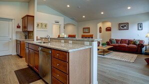 A modern kitchen with granite countertops, wooden cabinets, and a built-in dishwasher. - Fantastic Family Friendly Home w/ Moutain View, Huge Fenced yard, Private Backyard and Patio, A/ (Redmond)