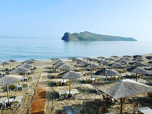 Rannalla, aurinkotuoleja, rantapyyhkeitä