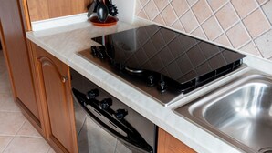 Eine Küche mit Herd, Backofen und Spüle.