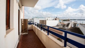 Ein Balkon mit Blick auf das Meer und Gebäude.