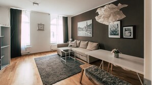 A modern living room with a sofa, a coffee table, a bench, and a white console table with a vase.