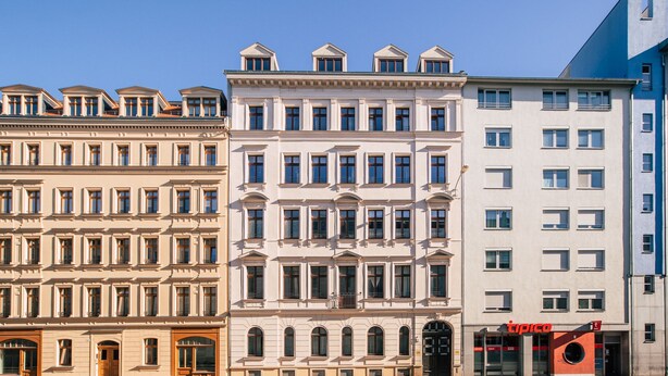A row of multi-story buildings with a mix of architectural styles, including classical and modern elements.