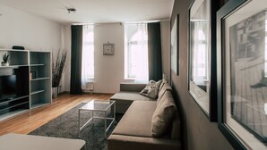 A modern living room with a sofa, a coffee table, and a TV stand.