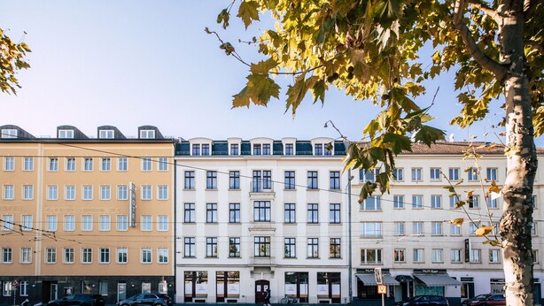 A multi-story hotel with a central courtyard, large windows, and a classic architectural style. - *Grand Botanical* 4-room apartment with kitchen - Luga Homes - Townhouse (Leipzig)