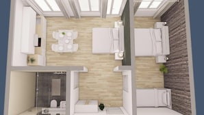 Et moderne hotelværelse med trægulv, et spiseområde med bord og stole, en separat opholdsstue med sofa og et badeværelse med bruser og toilet.
