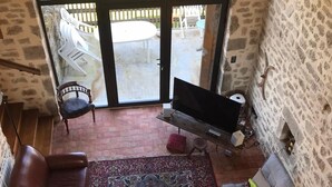 A cozy living room with a fireplace, a large window, and a patterned rug. - Large house in the Morvan (Lormes)