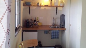 A compact kitchen with a wooden countertop, a sink, and a small dining table.