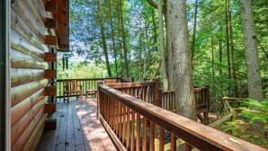 A wooden deck with benches and a railing, surrounded by a forested area. - Hazy Hideaway - Cherry Log, GA (Cherry Log)
